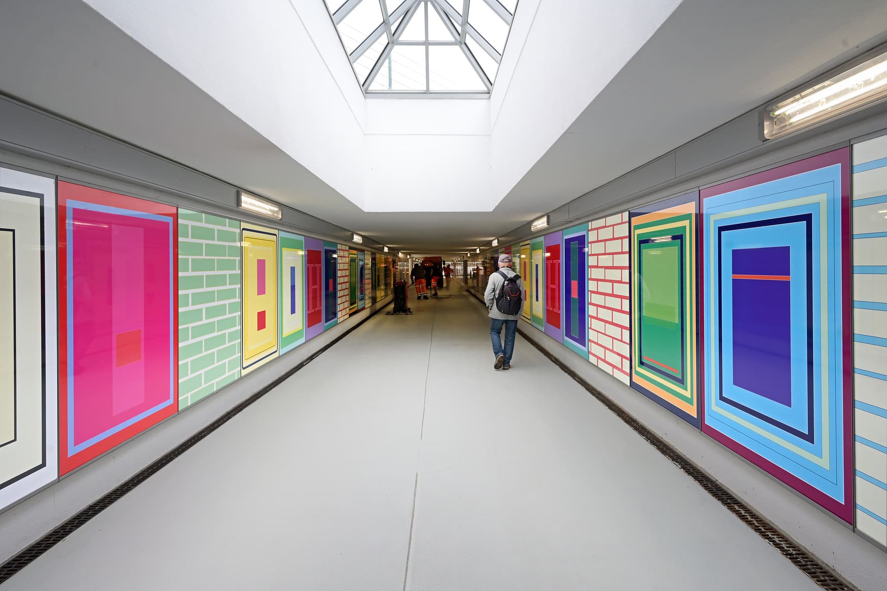 Zu sehen ist der Tunnel im Bahnhof Flöha. Links und rechts zieren großformatig gestaltete, grafische Bilder die Wände.