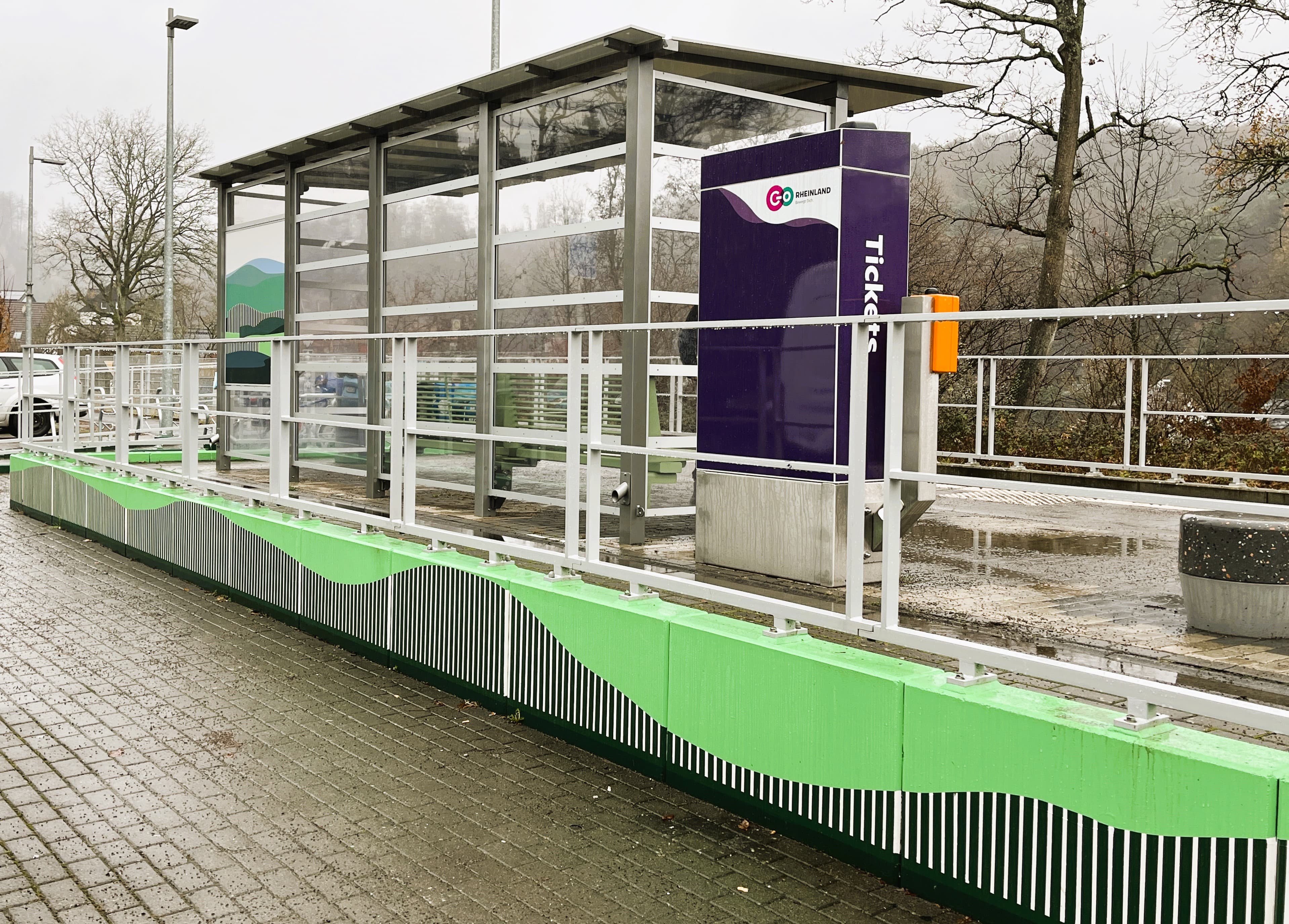 Blick auf das neue Wetterschutzhäuschen mit einer komplett neugestalteten Stützwand im Stile der bergischen Landschaft des Aggertals..