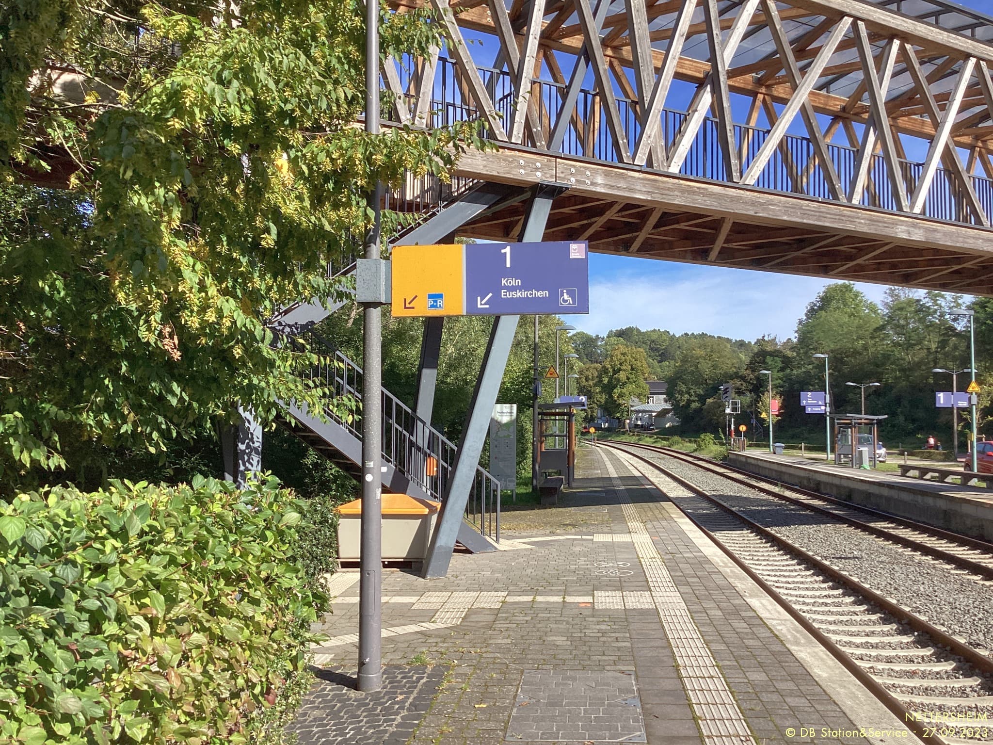 Alte Orientierungsschilder an einem Bahnsteig direkt vor den Gleisen.