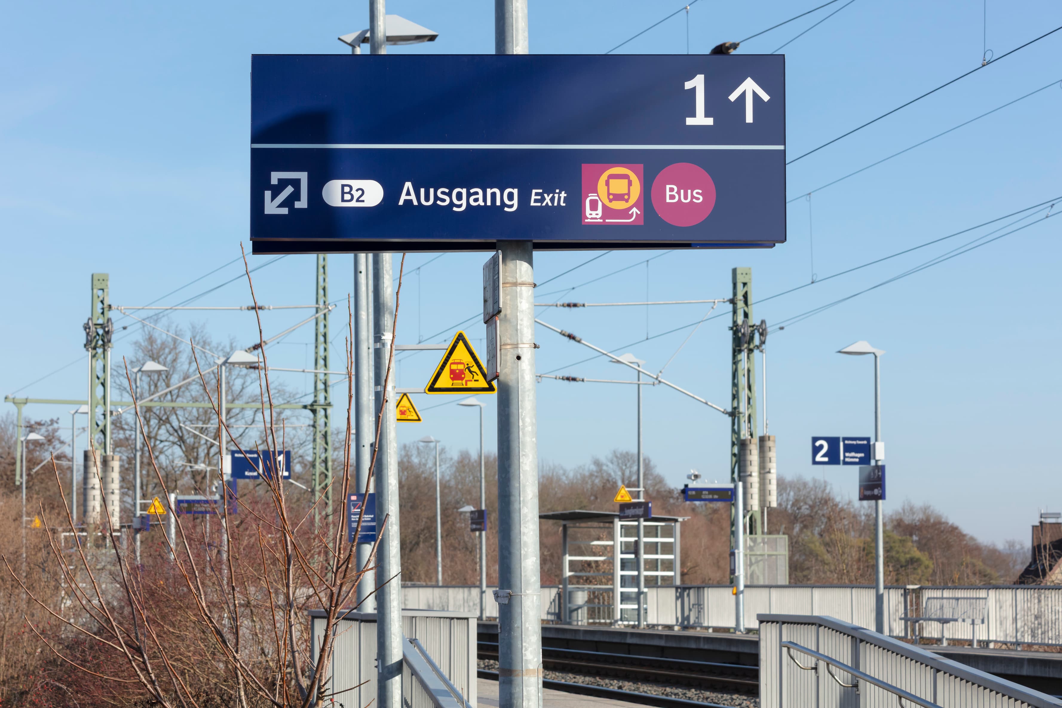 Blaues Schild mit Richtungspfeil zu Gleis 1 und Richtungspfeil zum Ausgang, Bus und Schienenersatzverkehr.