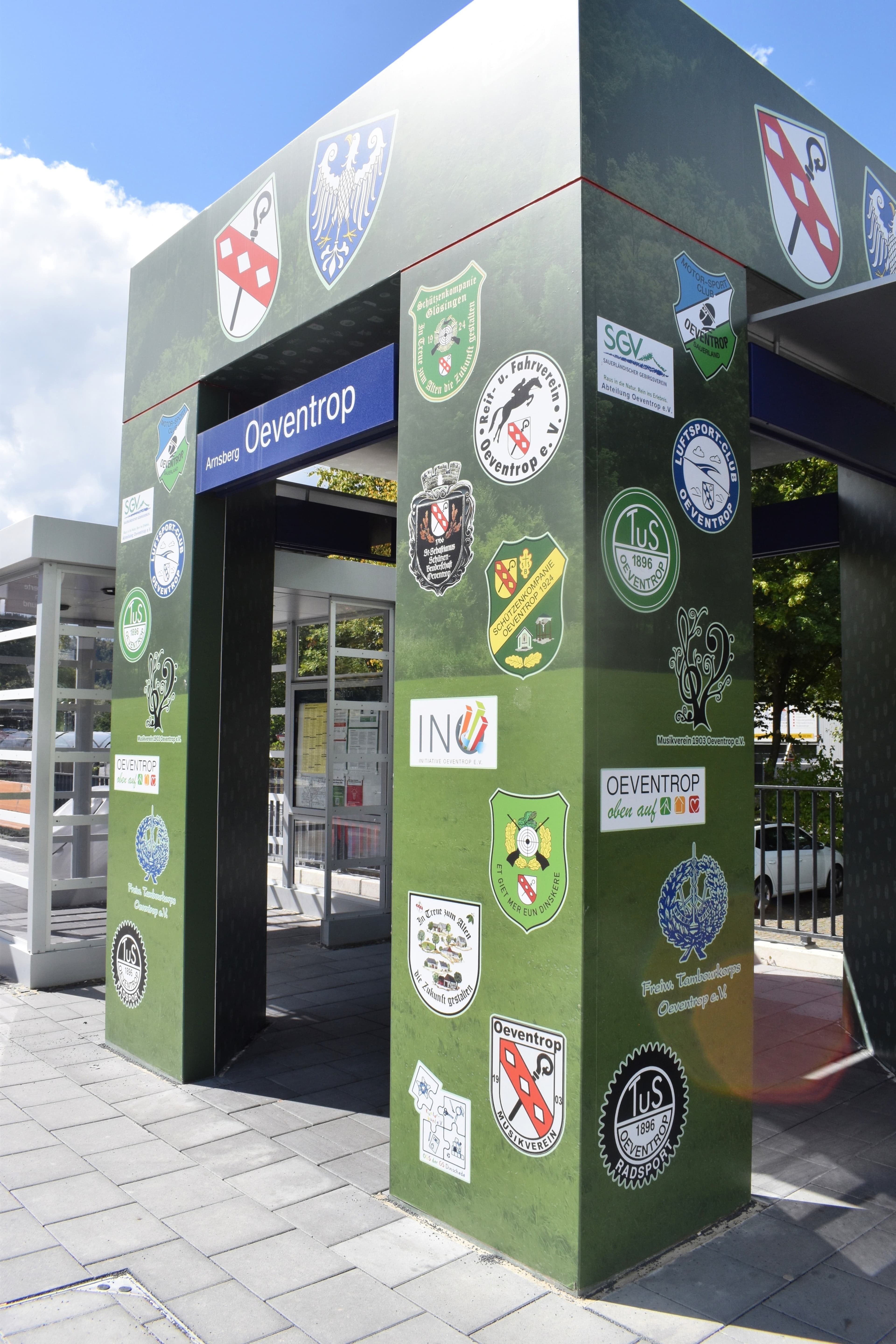 Der Wartebereich des Bahnsteigs zeigt die Logos der örtlichen Vereine