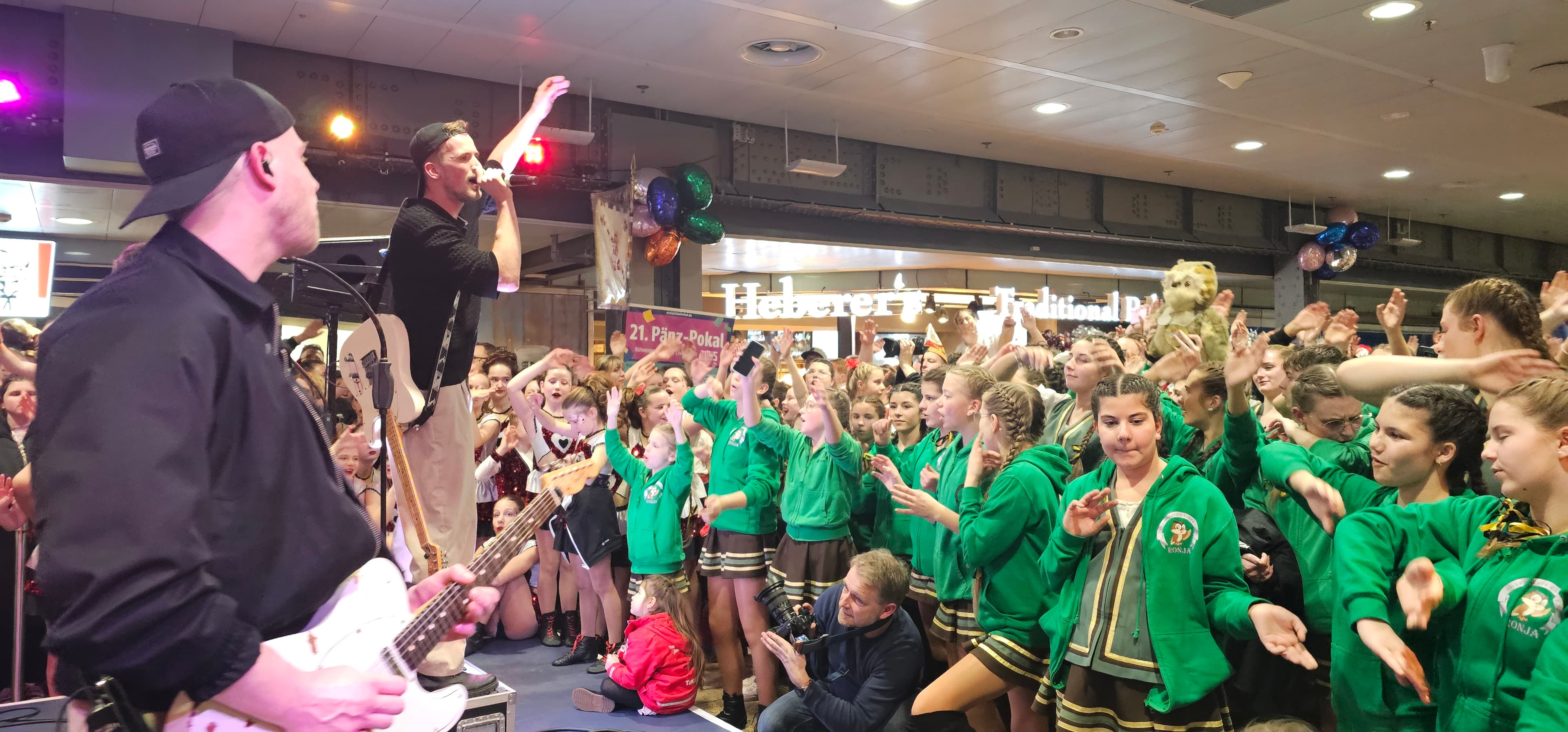 Musikband auf der Bühne. Feierndes Publikum.