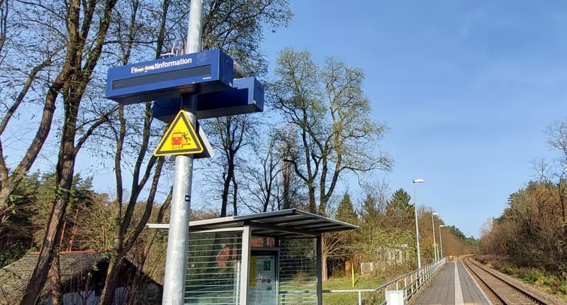 Ein Zuganzeiger und ein Wetterschutzhaus.