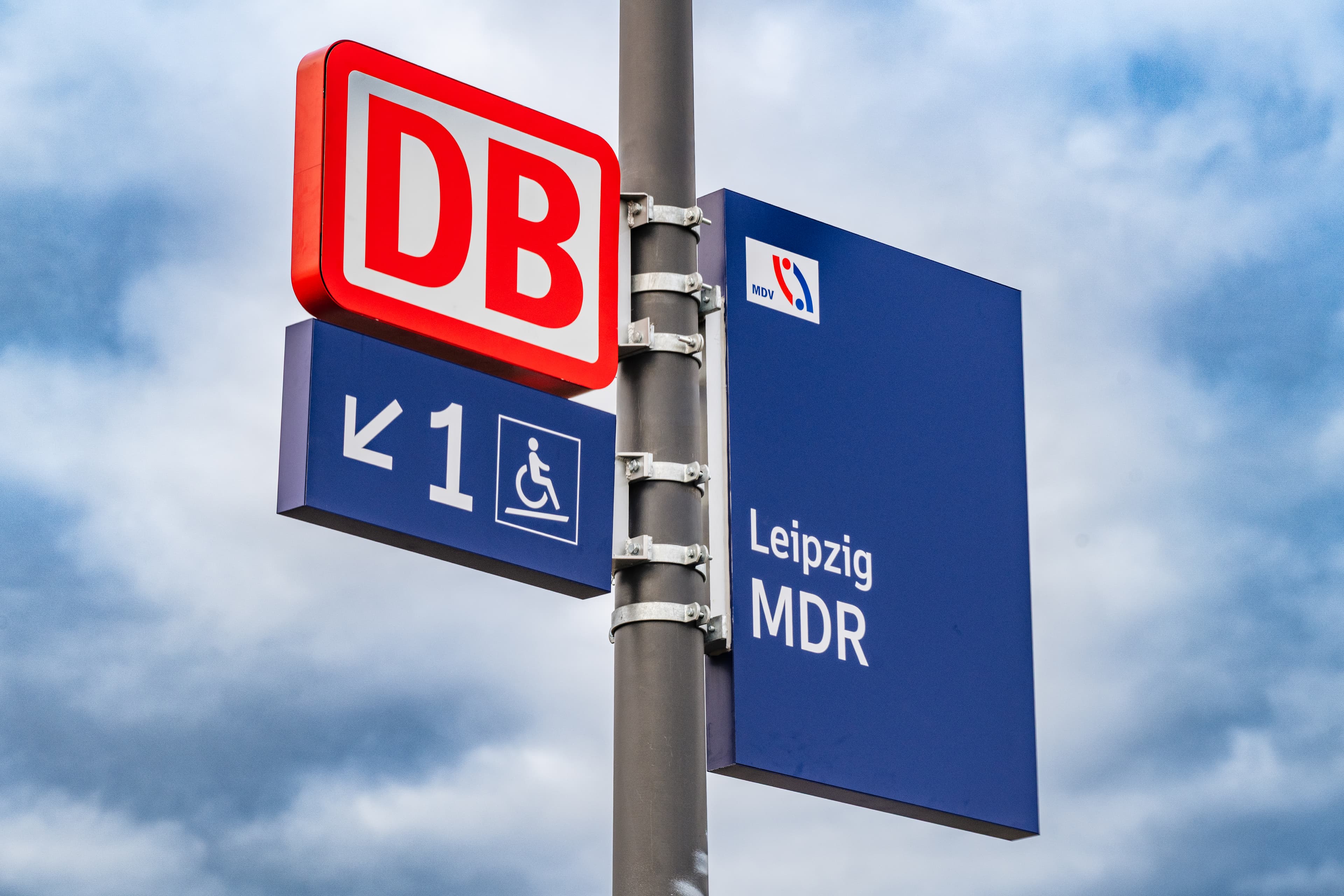 Die Stationsfahne ist jetzt statt rot blau, das DB Logo ist nicht mehr integriert, sondern als separates Logo einzeln am Mast angebracht.