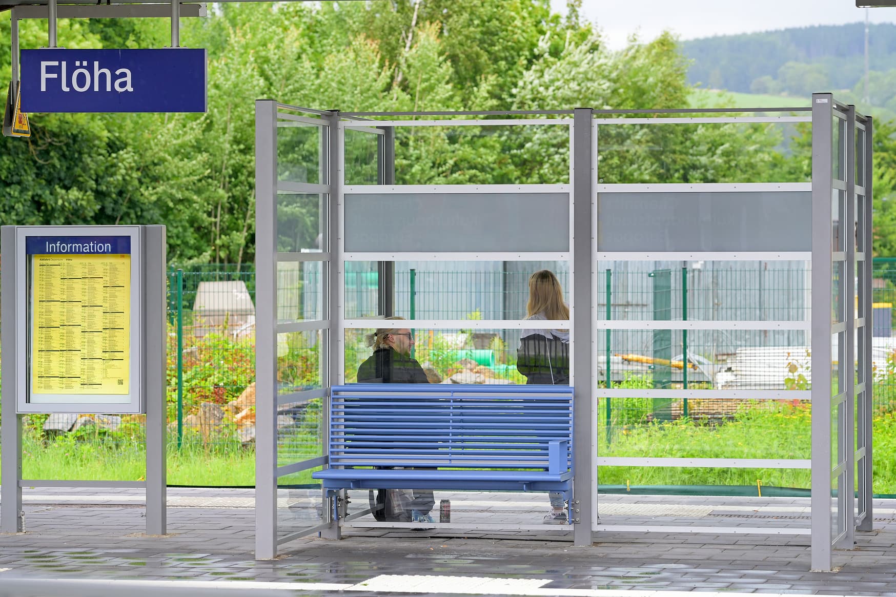 Zu sehen ist eine hellblaue Sitzbank, die zum Warten einlädt.