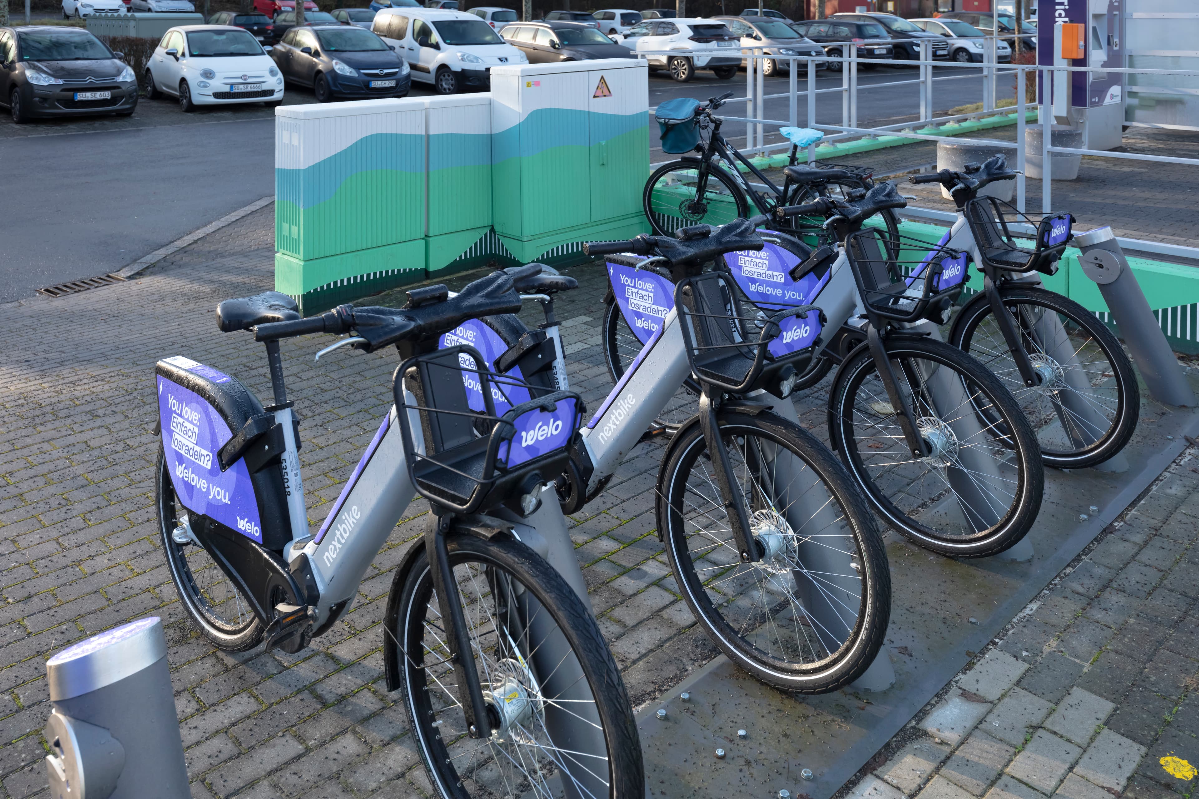 Vier Fahrräder sind an einer Fahrradabstellanlage geparkt.