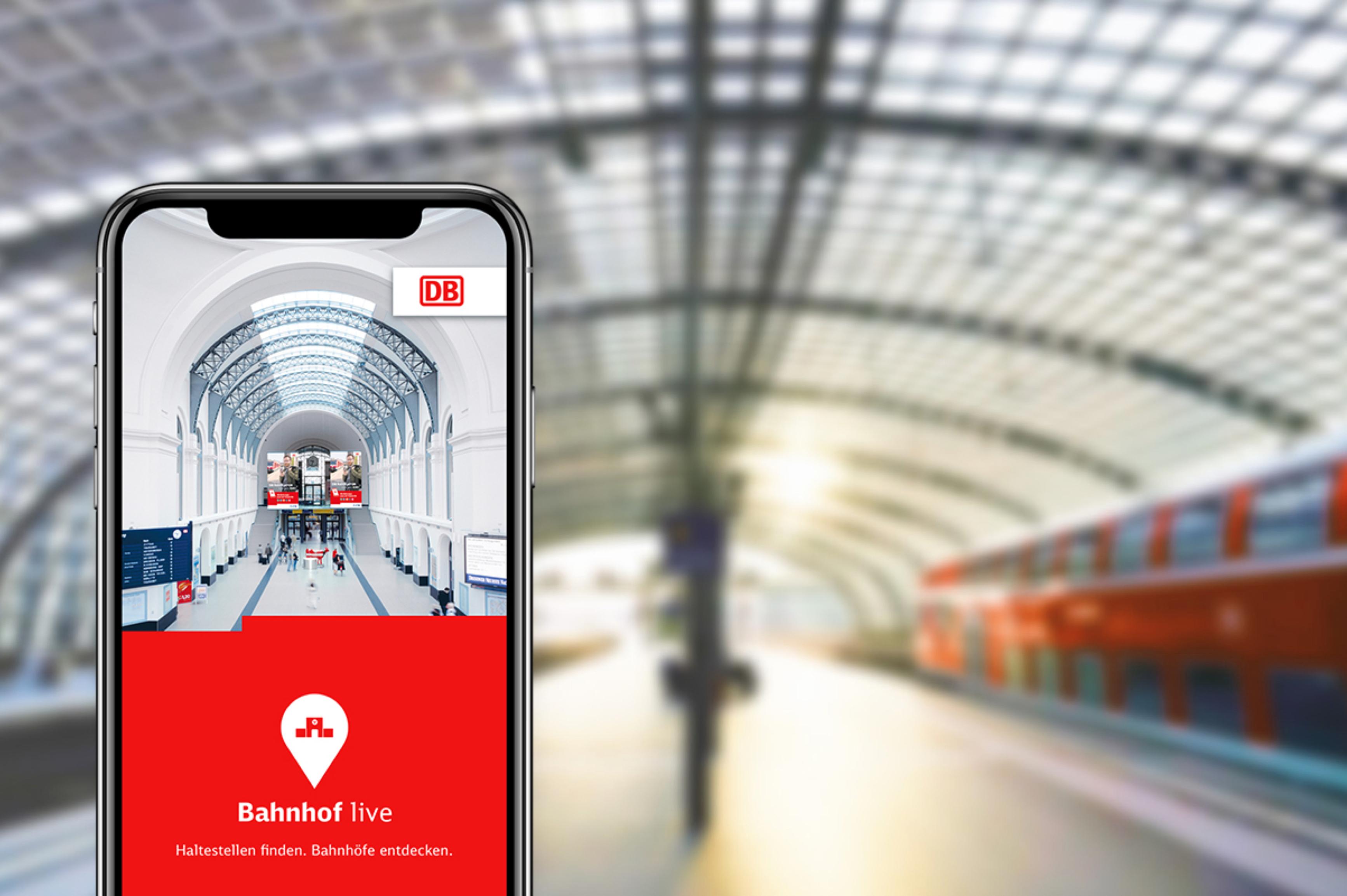 Vor dem Hintergrund eines Bahnsteiges mit einem haltenden Regionalzug wird ein Smartphone mit der geöffneten DB Bahnhof live App gezeigt.