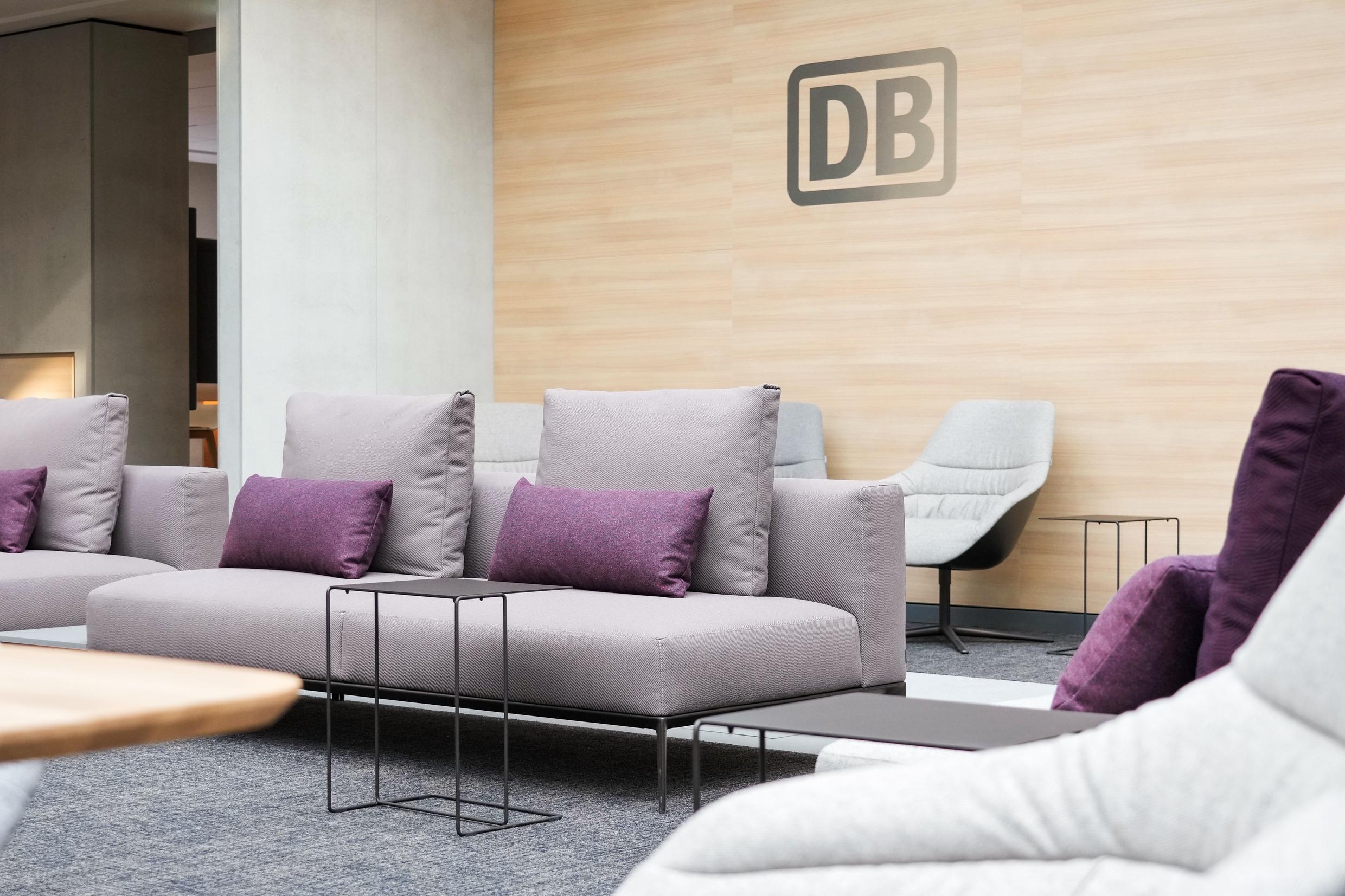 Modernes graues Sofa mit lila Kissen in der DB Premium Lounge Frankfurt (Main) Hauptbahnhof.