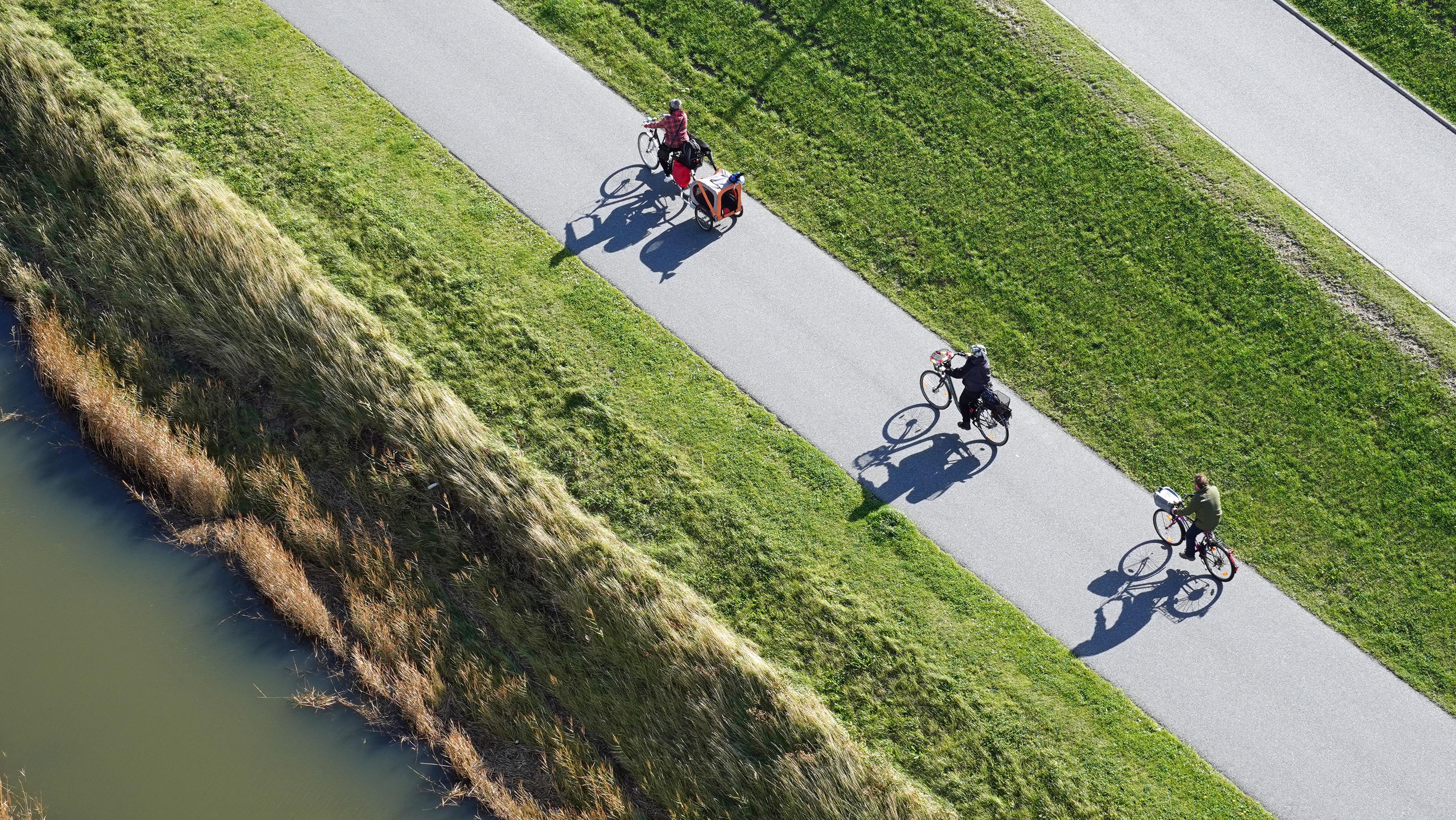 A cycle path with cyclists by the river.