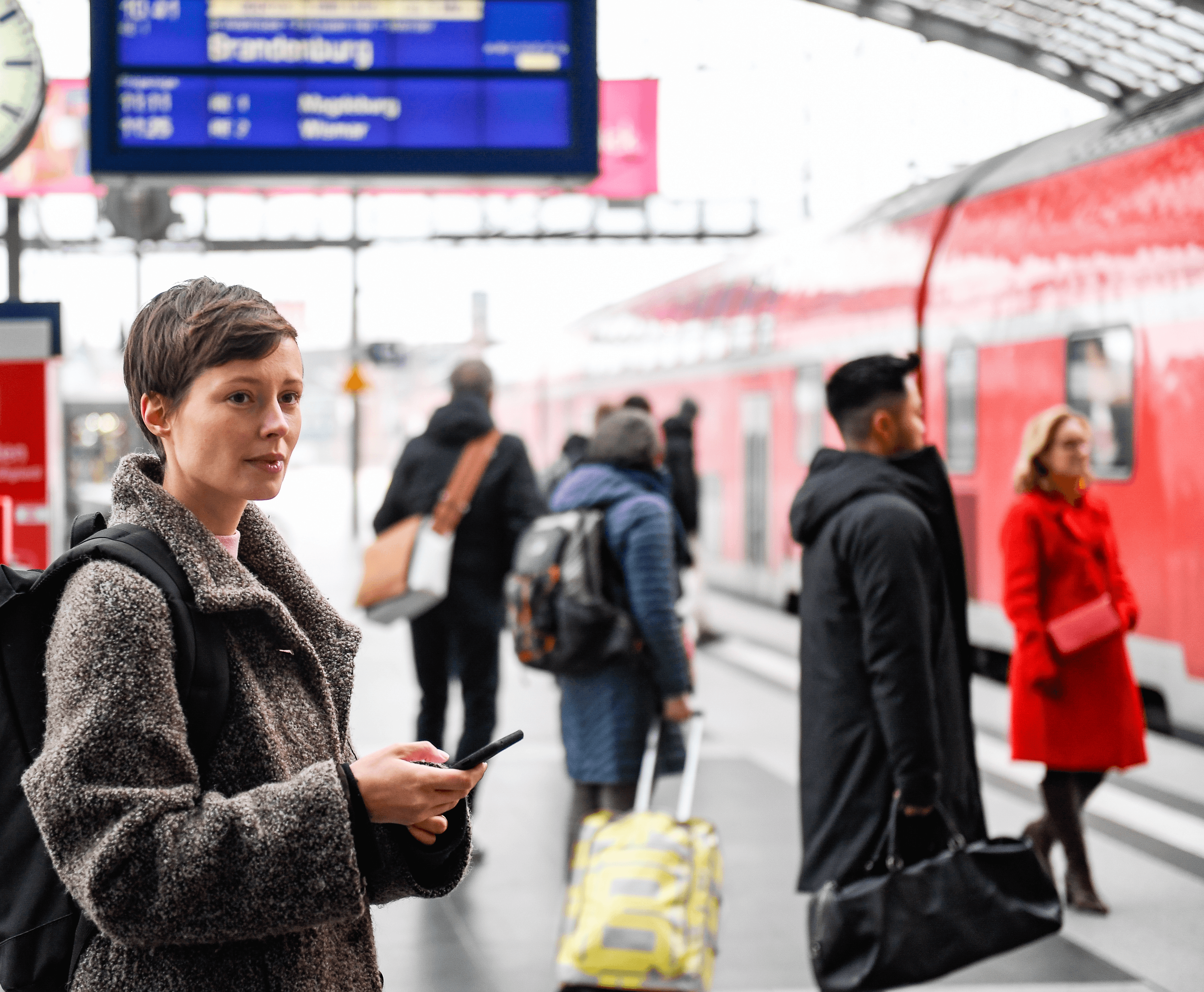 Eine Frau am Bahnsteig des Hauptbahnhofs Berlin mit einem Smartphone in der Hand.
